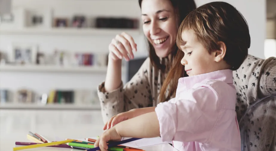 Jak pomóc wrócić dziecku do szkoły i przedszkola - mama z przedszkolakiem rysują kredkami